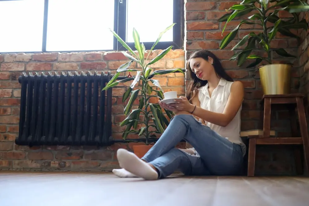 mujer en casa junto a su calefactor